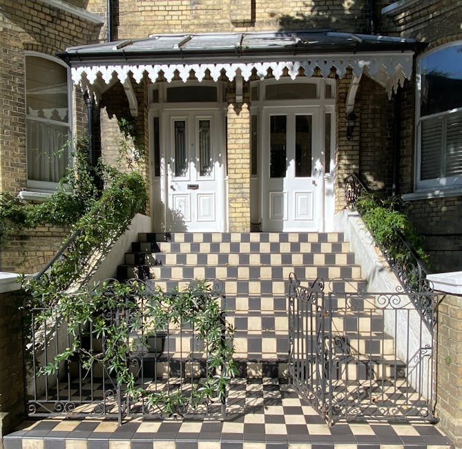 A front view of a Victorian terrace house with a tiled staircase leading up to two white-fronted doors, framed by brick walls. The staircase features a checkered tile pattern in black and beige, exten